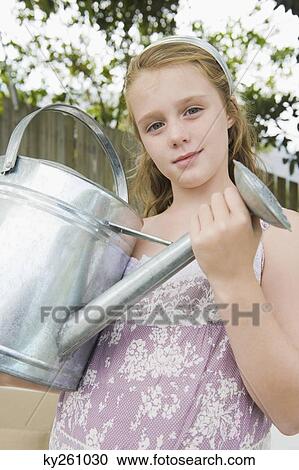 Stock Image - Portrait of a girl holding a watering can. Fotosearch