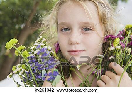 Portrait of a girl holding flowers View Large Photo Image Stock Image - Portrait of a girl holding flowers. Fotosearch