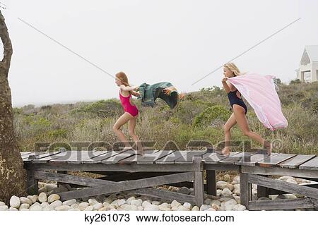 Two girls running on a boardwalk View Large Photo Image Stock Image - Two girls running on a boardwalk. Fotosearch