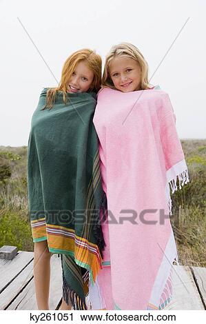Two girls standing on a boardwalk View Large Photo Image Stock Image - Two girls standing on a boardwalk. Fotosearch