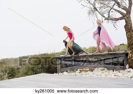 Two girls standing on a boardwalk View Large Photo Image Stock Photography - Two girls standing on a boardwalk. Fotosearch