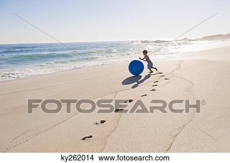 Boy playing with a beach ball View Large Photo Image Picture - Boy playing with a beach ball. Fotosearch
