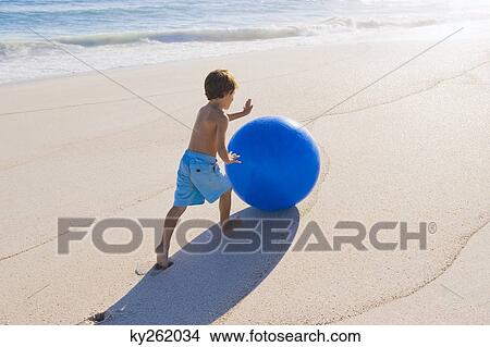 Picture - Boy playing with a beach ball. Fotosearch