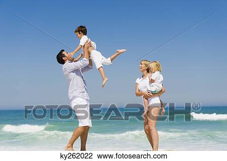 Stock Image - Family enjoying vacations on the beach. Fotosearch