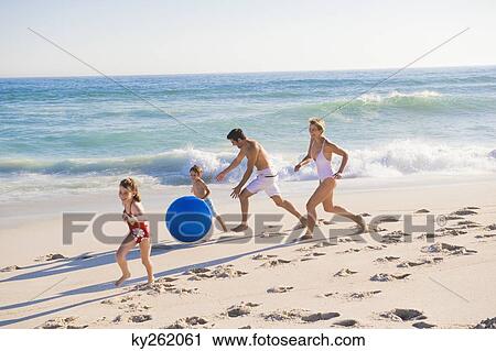 Stock Image - Family enjoying vacations on the beach. Fotosearch