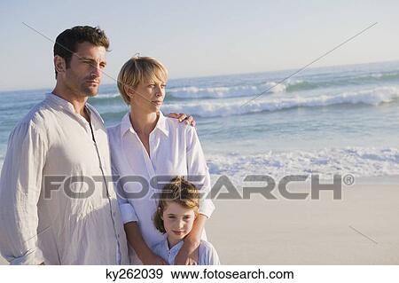 Stock Photo - Family standing on the beach. Fotosearch