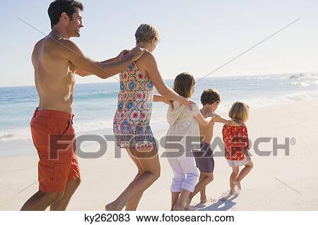 Family walking on the beach in train formation View Large Photo Image Stock Image - Family walking on the beach in train formation. Fotosearch