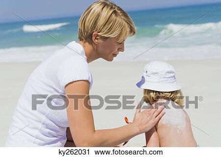 Woman applying suntan lotion on her daughter on the beach View Large Photo Image Stock Image - Woman applying suntan lotion on her daughter on the beach. Fotosearch