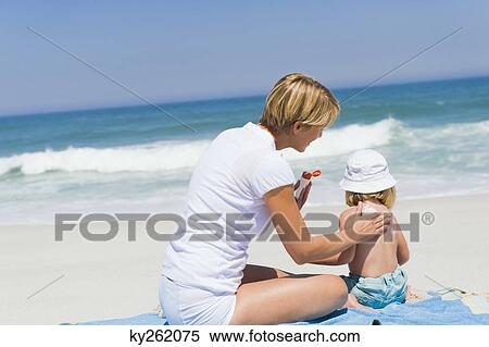Woman applying suntan lotion on her daughter on the beach View Large Photo Image Stock Photography - Woman applying suntan lotion on her daughter on the beach. Fotosearch