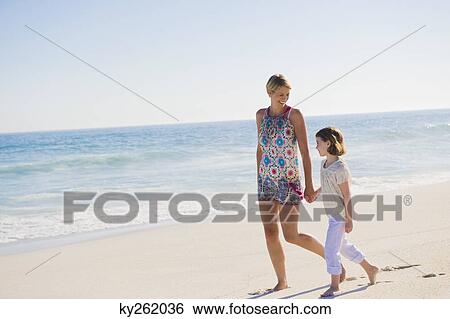 Woman walking on the beach with her daughter View Large Photo Image Stock Photograph - Woman walking on the beach with her daughter. Fotosearch