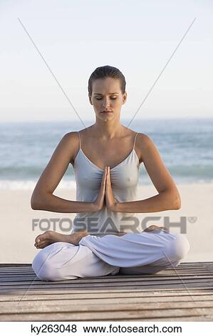 Woman meditating on a boardwalk View Large Photo Image Stock Photo - Woman meditating on a boardwalk. Fotosearch