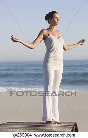 Woman practicing yoga on a boardwalk View Large Photo Image Picture - Woman practicing yoga on a boardwalk. Fotosearch
