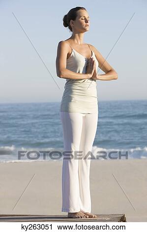 Woman practicing yoga on a boardwalk View Large Photo Image Stock Image - Woman practicing yoga on a boardwalk. Fotosearch