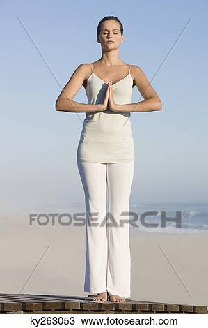 Woman practicing yoga on a boardwalk View Large Photo Image Stock Image - Woman practicing yoga on a boardwalk. Fotosearch