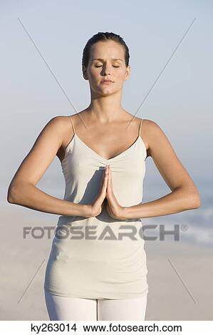 Picture - Woman practicing yoga on the beach. Fotosearch