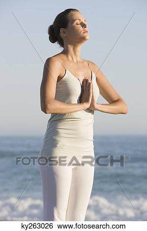 Woman practicing yoga on the beach View Large Photo Image Stock Photograph - Woman practicing yoga on the beach. Fotosearch