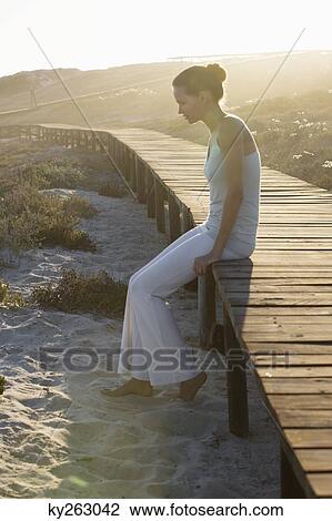 Woman sitting on a boardwalk and thinking View Large Photo Image Stock Image - Woman sitting on a boardwalk and thinking. Fotosearch