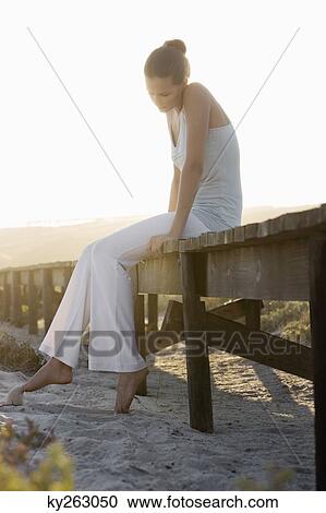 Woman sitting on a boardwalk and thinking View Large Photo Image Stock Image - Woman sitting on a boardwalk and thinking. Fotosearch