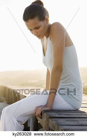 Woman sitting on a boardwalk and thinking View Large Photo Image Stock Photo - Woman sitting on a boardwalk and thinking. Fotosearch