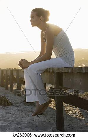 Woman sitting on a boardwalk and thinking View Large Photo Image Stock Photograph - Woman sitting on a boardwalk and thinking. Fotosearch