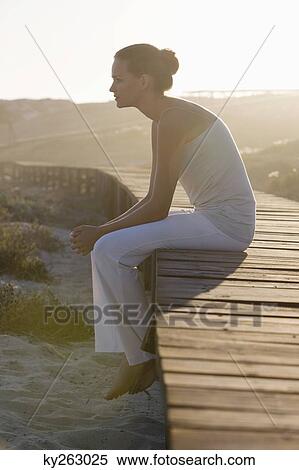Woman sitting on a boardwalk and thinking View Large Photo Image Stock Photography - Woman sitting on a boardwalk and thinking. Fotosearch