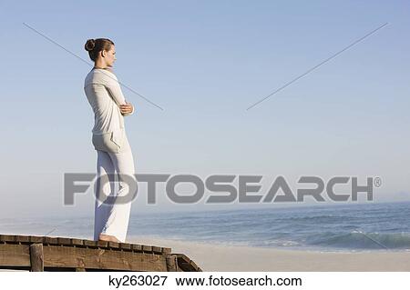 Woman standing on a boardwalk looking at a view View Large Photo Image Stock Photo - Woman standing on a boardwalk looking at a view. Fotosearch