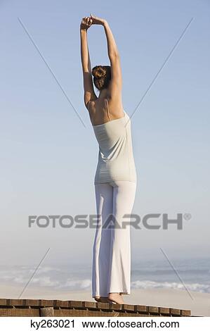 Woman stretching her arms on a boardwalk View Large Photo Image Stock Image - Woman stretching her arms on a boardwalk. Fotosearch