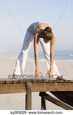 Woman stretching on a boardwalk View Large Photo Image Stock Photo - Woman stretching on a boardwalk. Fotosearch