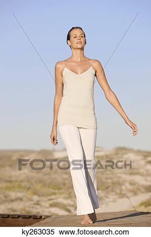 Stock Photography - Woman walking on a boardwalk. Fotosearch