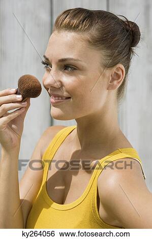 Woman applying make-up on her face View Large Photo Image Stock Photograph - Woman applying make-up on her face. Fotosearch