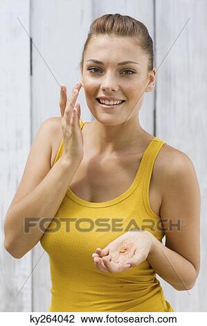 Woman applying moisturizer on her face View Large Photo Image Stock Image - Woman applying moisturizer on her face. Fotosearch