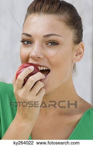 Woman eating an apple and smiling View Large Photo Image Stock Image - Woman eating an apple and smiling. Fotosearch
