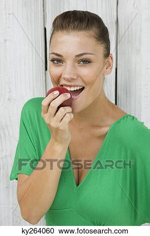 Woman eating an apple and smiling View Large Photo Image Stock Image - Woman eating an apple and smiling. Fotosearch