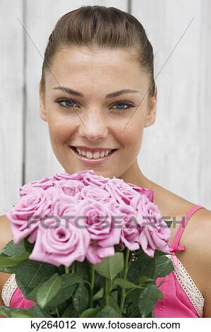Woman holding a bouquet of roses and smiling View Large Photo Image Stock Image - Woman holding a bouquet of roses and smiling. Fotosearch