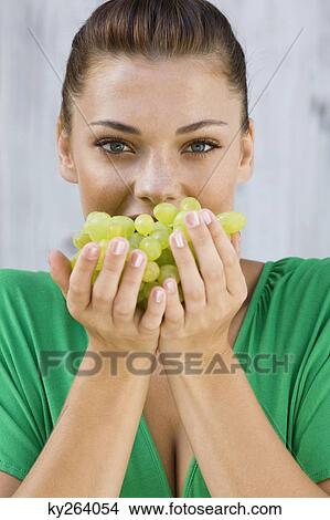 Woman holding a bunch of grapes View Large Photo Image Picture - Woman holding a bunch of grapes. Fotosearch