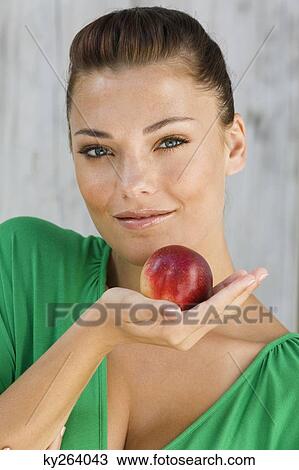 Woman holding an apple and smiling View Large Photo Image Stock Image - Woman holding an apple and smiling. Fotosearch