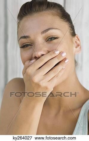 Woman smiling with her hand on her mouth View Large Photo Image Stock Photo - Woman smiling with her hand on her mouth. Fotosearch