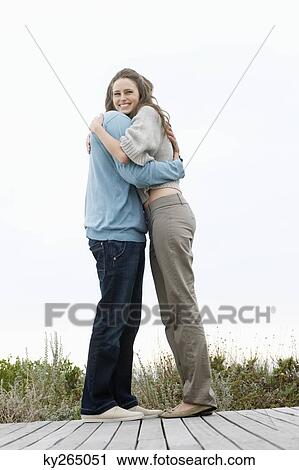 Couple embracing each other on a boardwalk View Large Photo Image Stock Image - Couple embracing each other on a boardwalk. Fotosearch