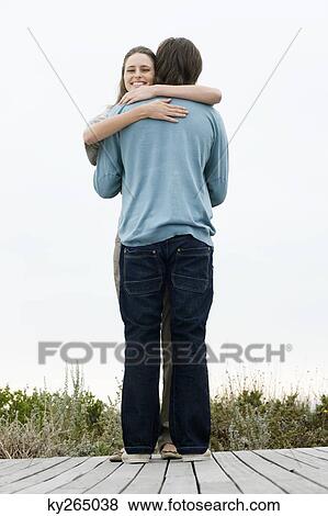 Couple embracing each other on a boardwalk View Large Photo Image Stock Photo - Couple embracing each other on a boardwalk. Fotosearch