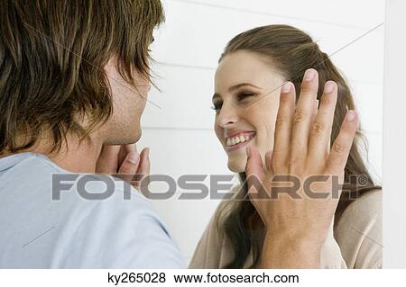 Stock Photo - Couple looking at each other and smiling. Fotosearch