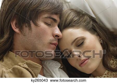 Stock Image - Couple resting on the bed. Fotosearch