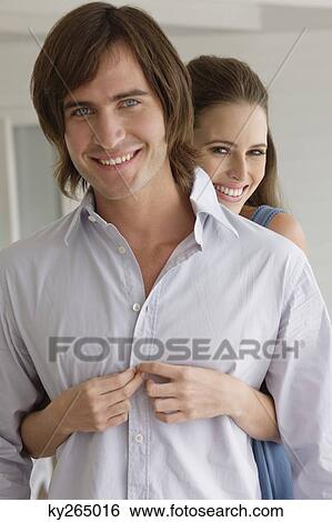 Stock Photograph - Woman embracing a man from behind. Fotosearch