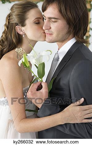 Stock Image - Bride kissing groom. Fotosearch