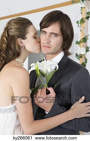 Stock Image - Bride kissing groom. Fotosearch