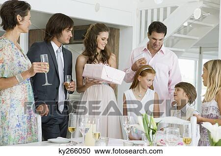 Stock Image - Bride receiving a gift from a guest in a party. Fotosearch