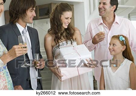 Stock Image - Bride receiving gifts from guests in a party. Fotosearch