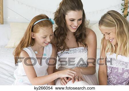Bride showing her wedding ring to girls View Large Photo Image Picture - Bride showing her wedding ring to girls. Fotosearch