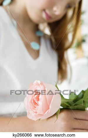 Stock Photograph - Close-up of a flower girl holding a flower. Fotosearch