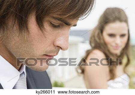 Stock Image - Close-up of a groom beside a bride. Fotosearch