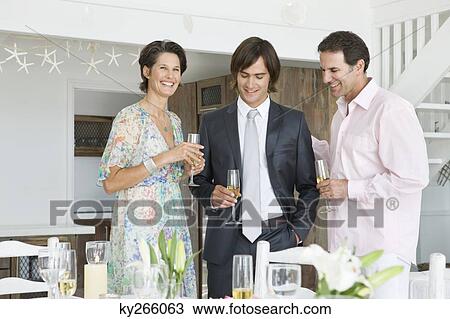Stock Image - Man drinking champagne with his parents. Fotosearch
